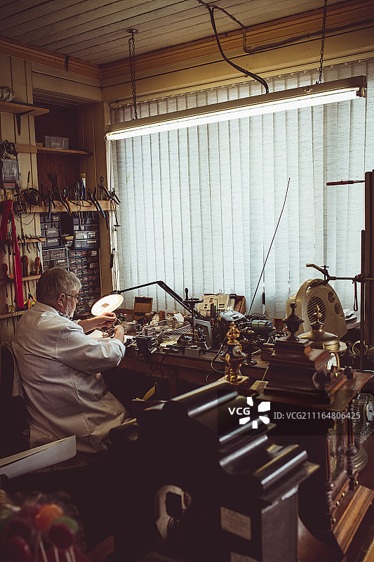 钟表匠修理手表的背影图片素材