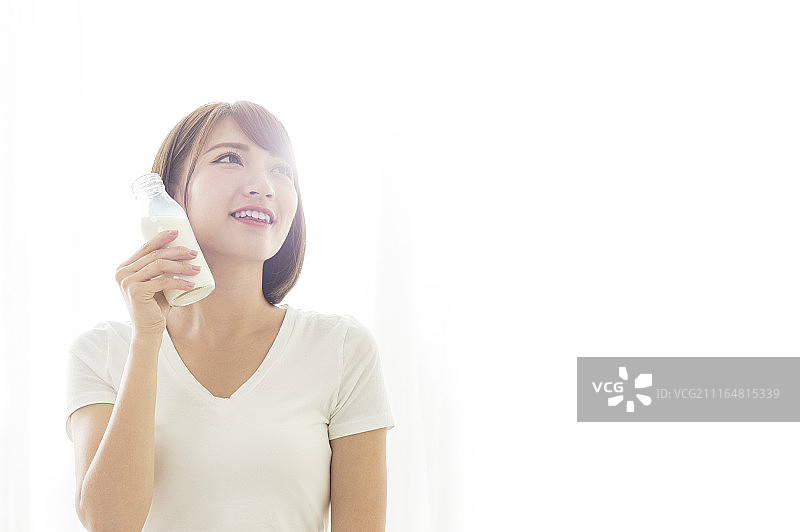 年轻女人早晨起床喝牛奶图片素材