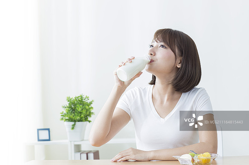 年轻女人早晨起床喝牛奶图片素材