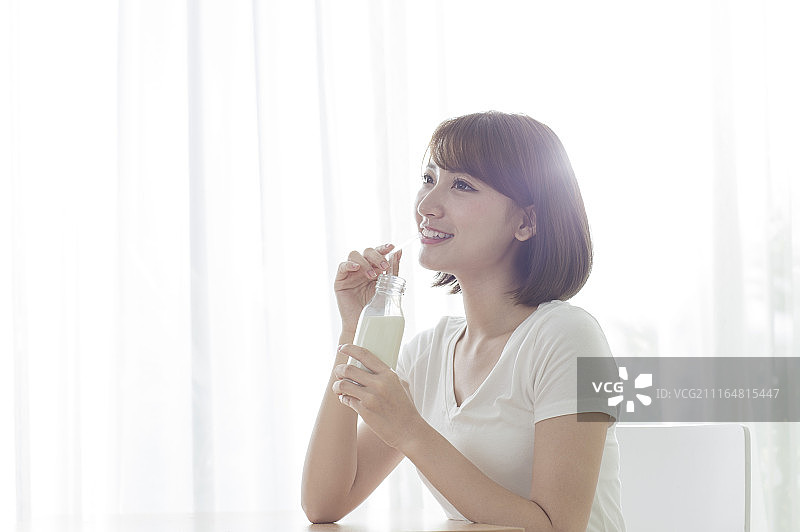 年轻女人早晨起床喝牛奶图片素材