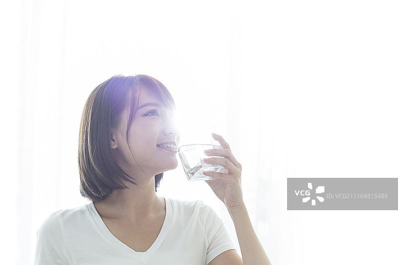 年轻女人早晨起床喝水图片素材