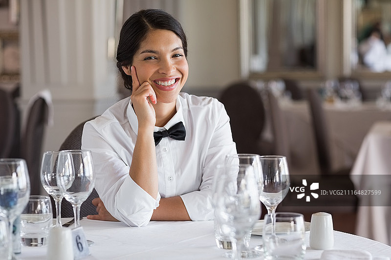餐桌旁的美丽女服务员图片素材