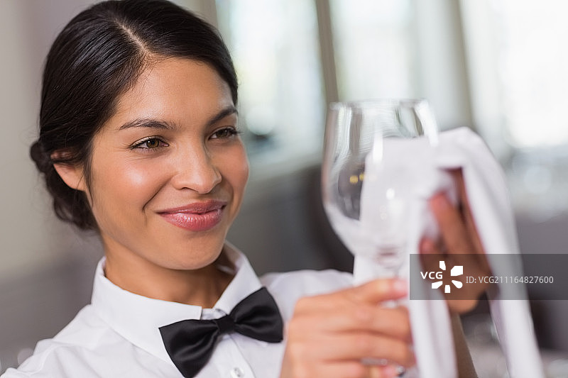擦拭酒杯的漂亮女服务员图片素材