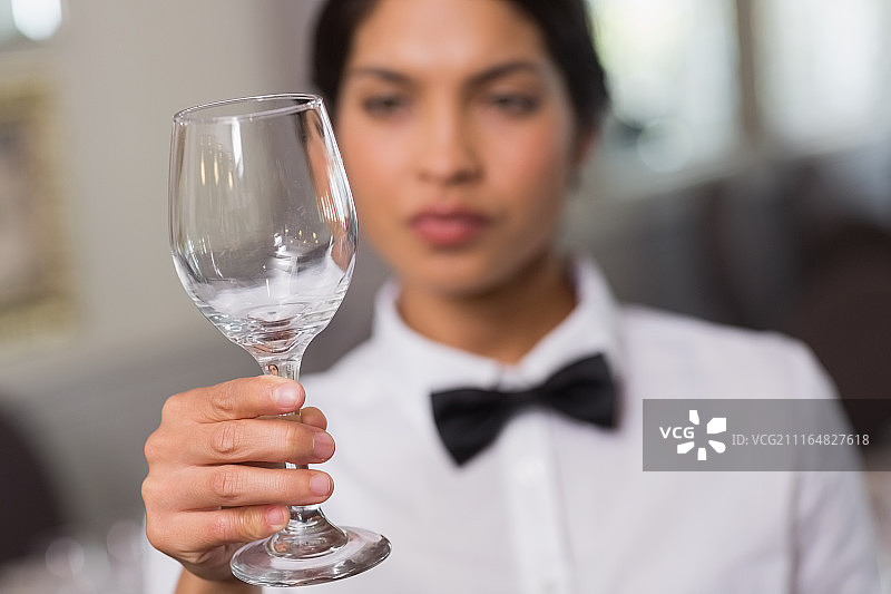 漂亮的女服务员举着一个酒杯图片素材