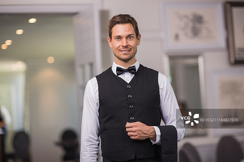 对着镜头微笑的英俊男服务员图片素材