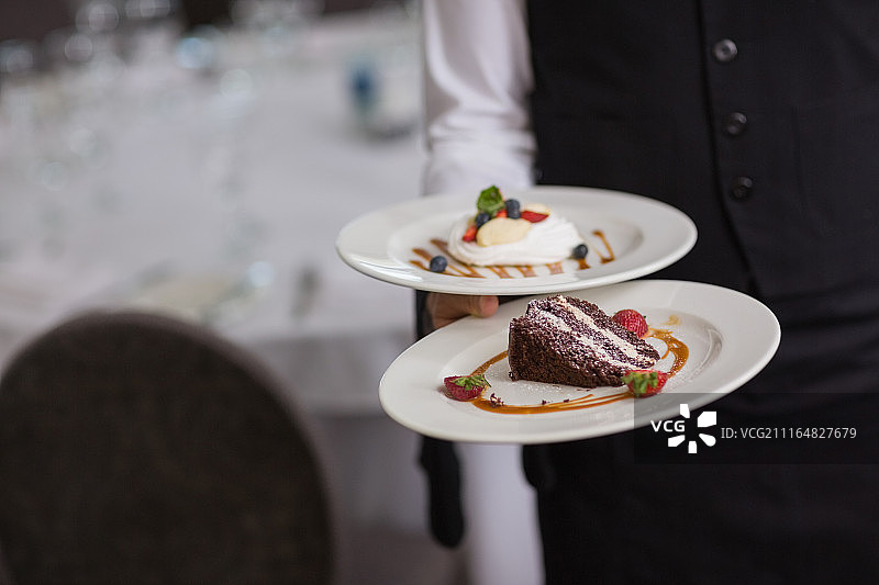 服务员展示两盘甜点图片素材