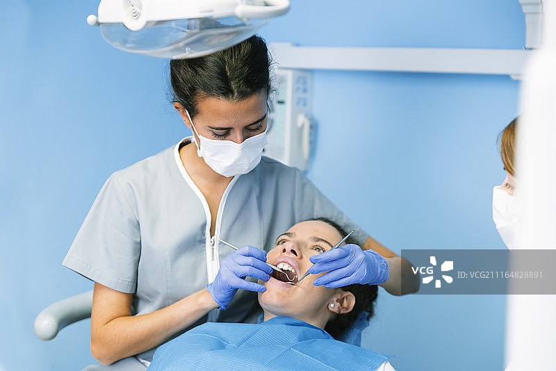 牙医在牙科诊所为患者看诊图片素材