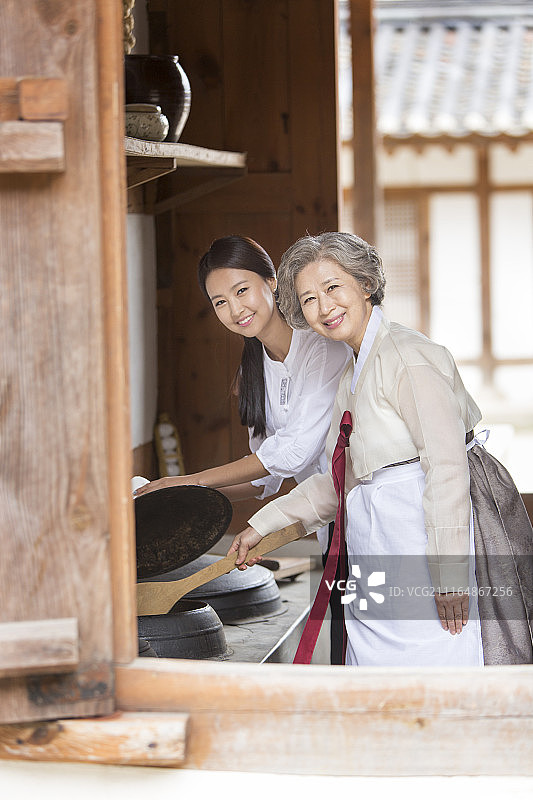 婆婆和儿媳穿着韩服准备食物的摄影作品图片素材