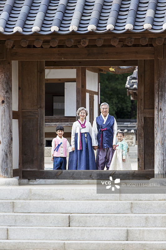 穿着韩服的祖父母和孙辈站在韩国传统房屋门口的摄影作品图片素材