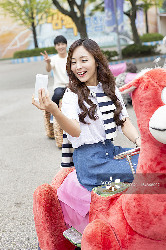 游乐园情侣乘坐游乐设施自拍摄影图片素材