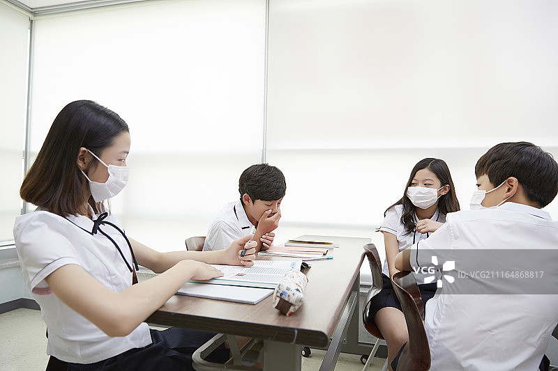 十几岁的学生在教室里戴面具的照片图片素材