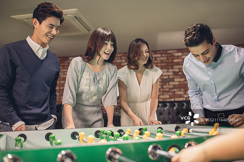 两男两女玩桌上足球的摄影作品图片素材