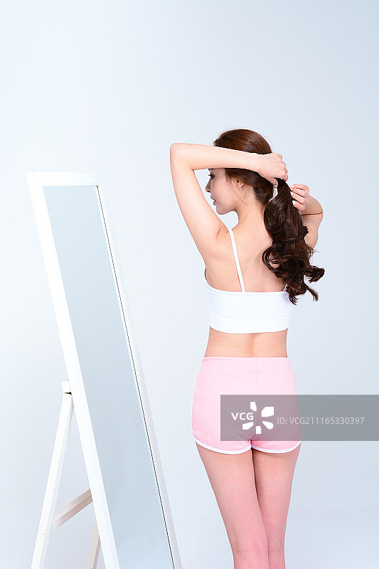 年轻女人正在涂抹头发护理品图片素材