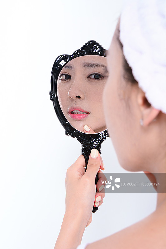 年轻漂亮的健康女性和镜子里的倒影图片素材