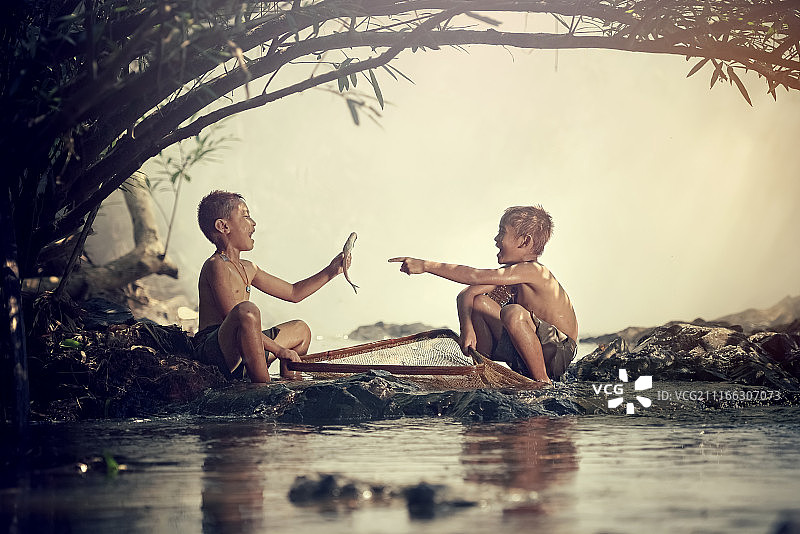 两个男孩在河里钓鱼图片素材