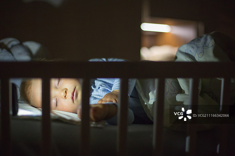 夜晚在婴儿床中睡觉的婴儿图片素材