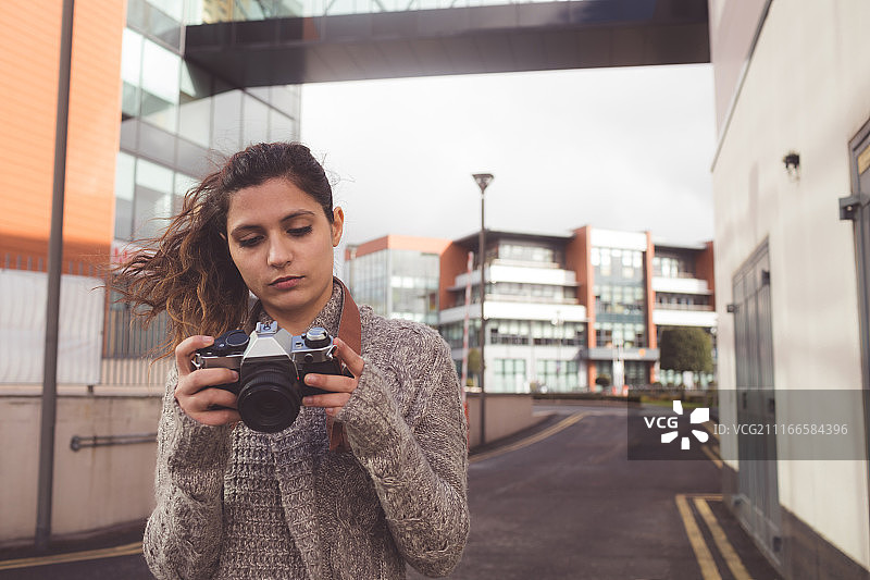 女人用数码相机查看照片图片素材