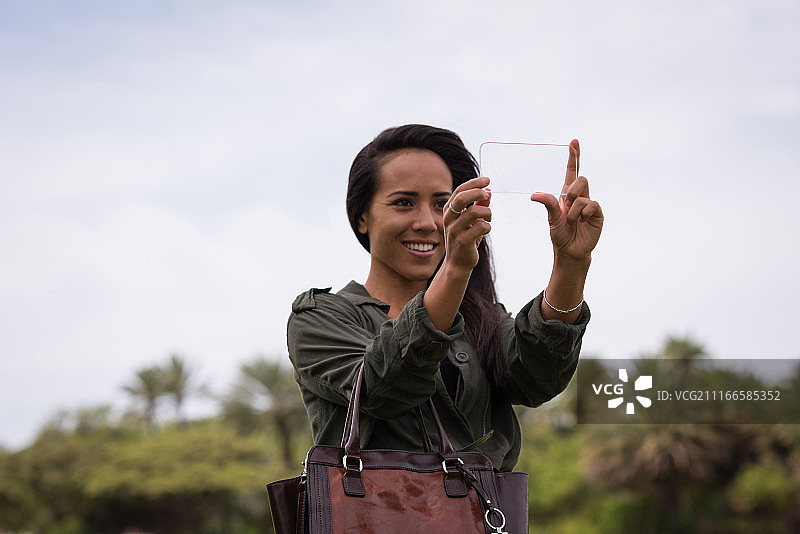 在公园里使用玻璃手机的女人图片素材