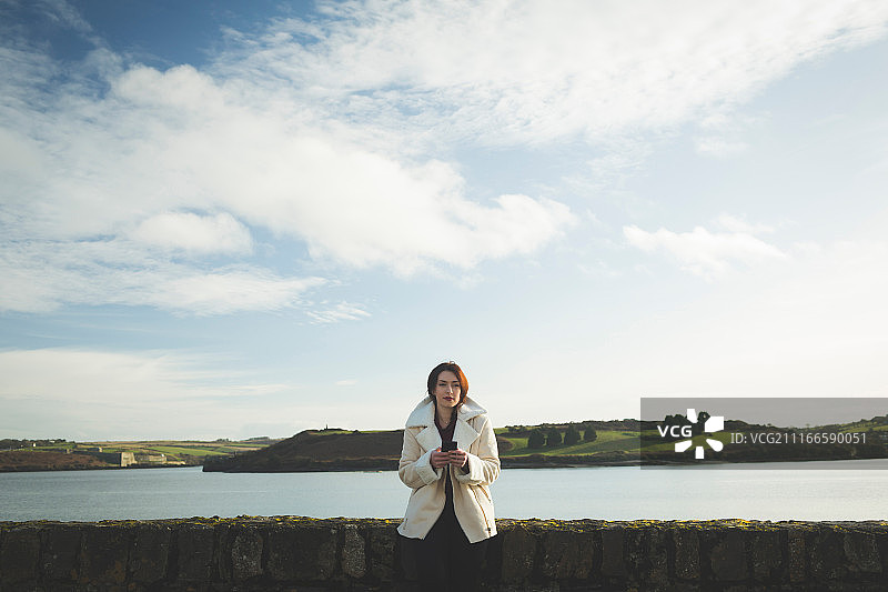 在河边附近使用手机的女人图片素材