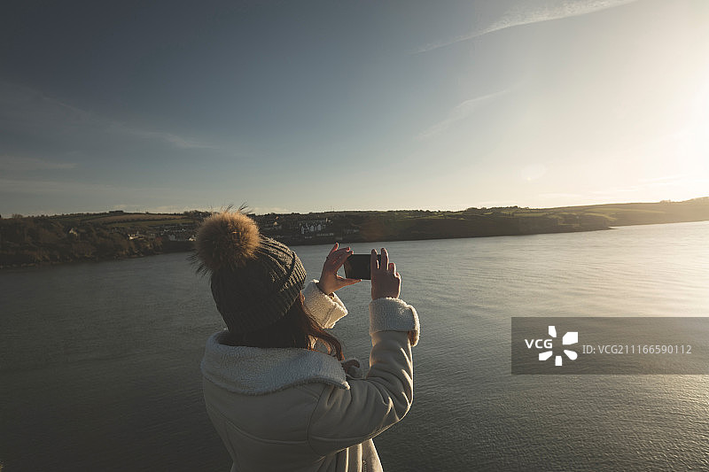 女人在河边用手机拍照图片素材
