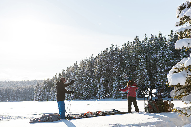 情侣在雪地里搭帐篷图片素材