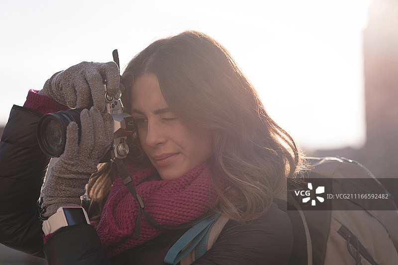 女人在晴天用相机拍照图片素材