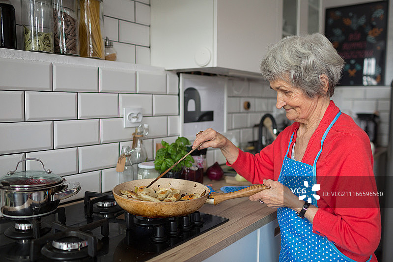 年长妇女在厨房做饭图片素材