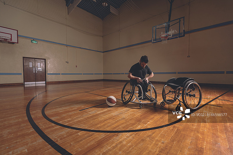 正在调整轮椅腰带的残疾男子图片素材