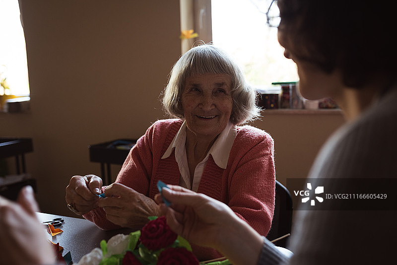 在疗养院与护理人员互动的老年妇女图片素材