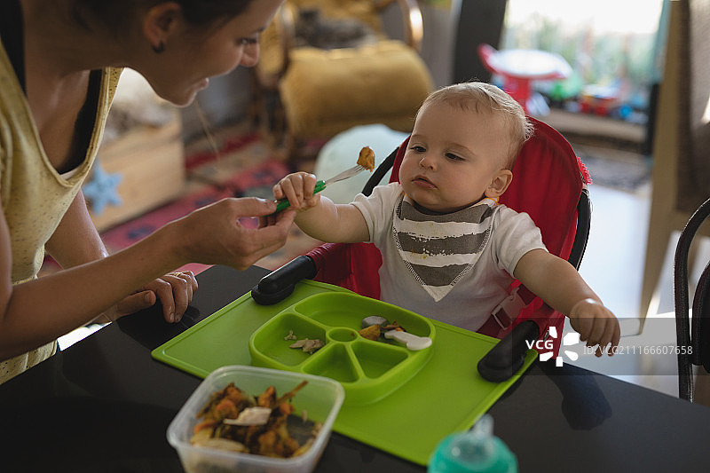 母亲在厨房喂宝宝图片素材