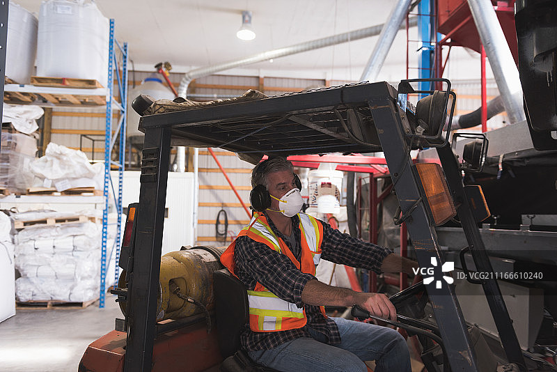 身穿防护服的男子坐在叉车上图片素材