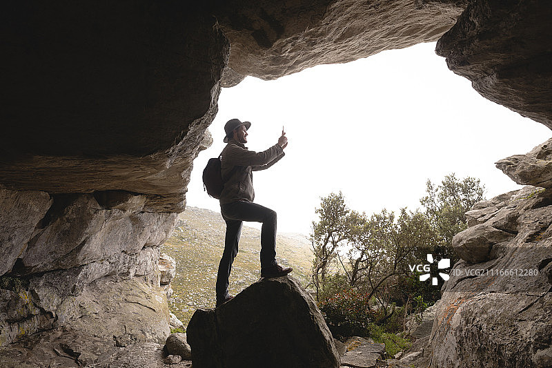 徒步者站在洞口拍照图片素材