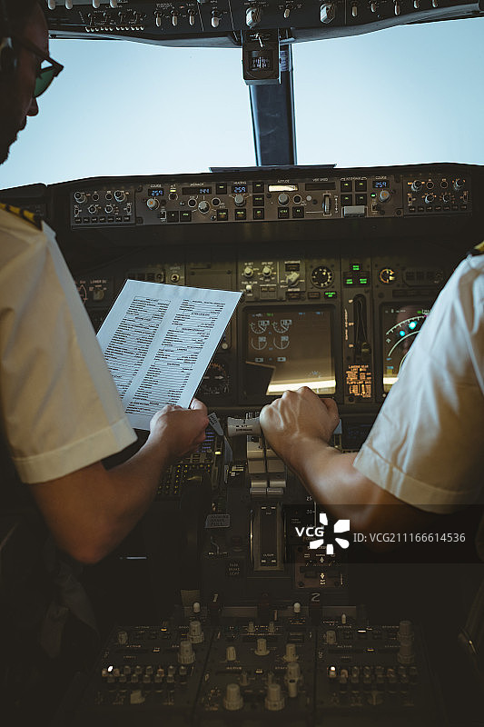 飞行员和副驾驶查看飞机上的说明书图片素材