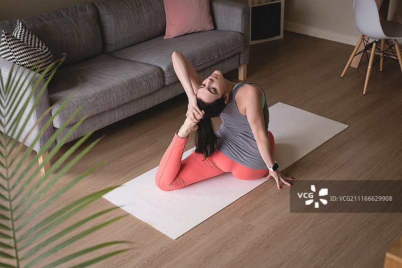 在家做单腿鸽王式的年轻女子（高角度视角）图片素材
