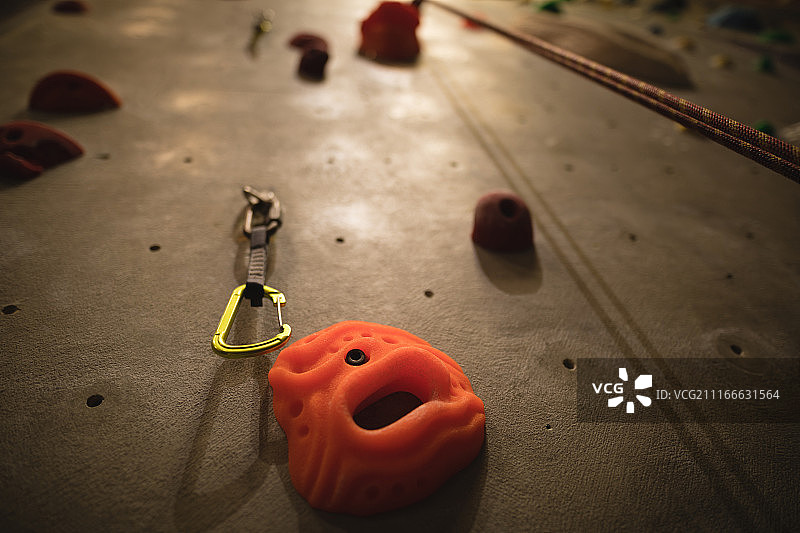 挂在攀岩墙上的登山扣的仰视角度照片图片素材