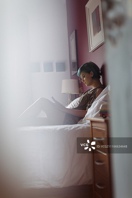 在床上用手机的放松女人图片素材