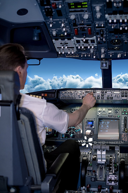 年轻男飞行员在飞行器中切换控制图片素材