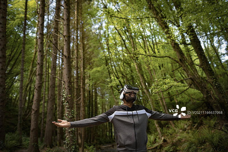 戴VR眼镜，张开双臂站立的男人图片素材