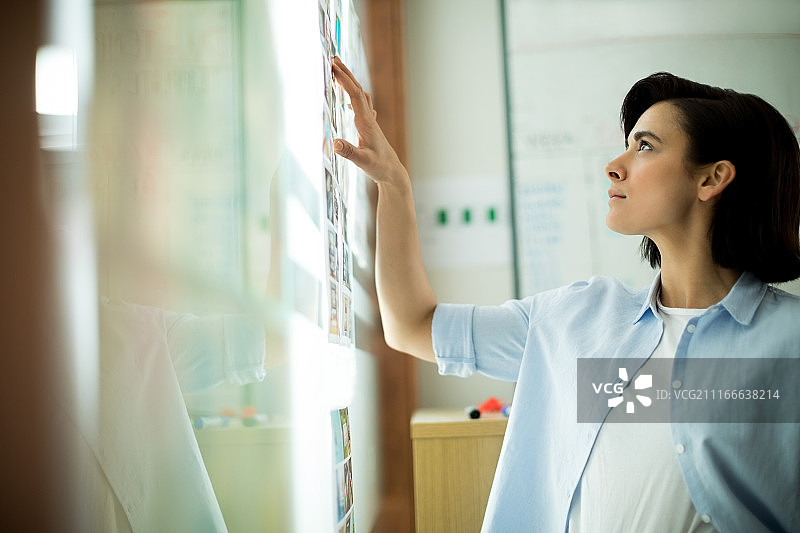 高管查看贴在玻璃上的照片图片素材