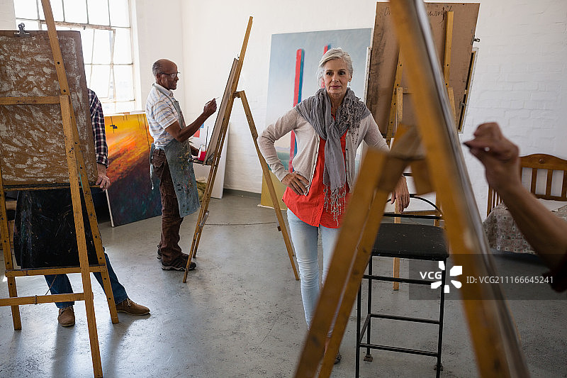 年长的女性站在椅子旁，艺术家正在素描图片素材
