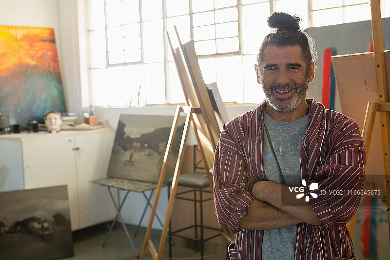 面带微笑的成熟艺术家，双臂交叉的肖像图片素材