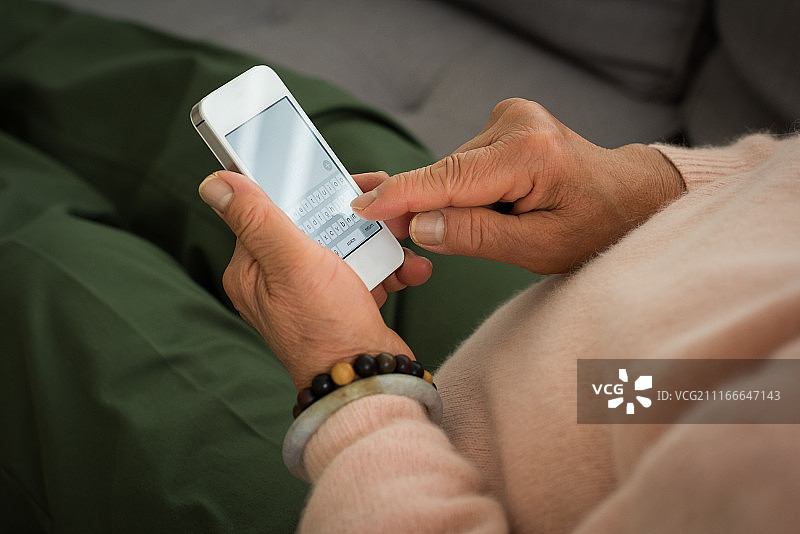 使用智能手机的年长妇女身体中部照片图片素材