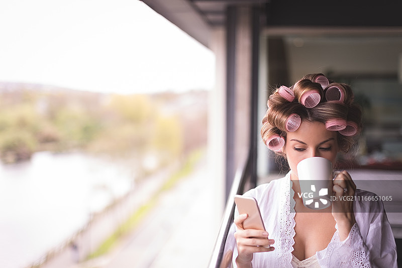 新娘边喝咖啡边使用手机图片素材