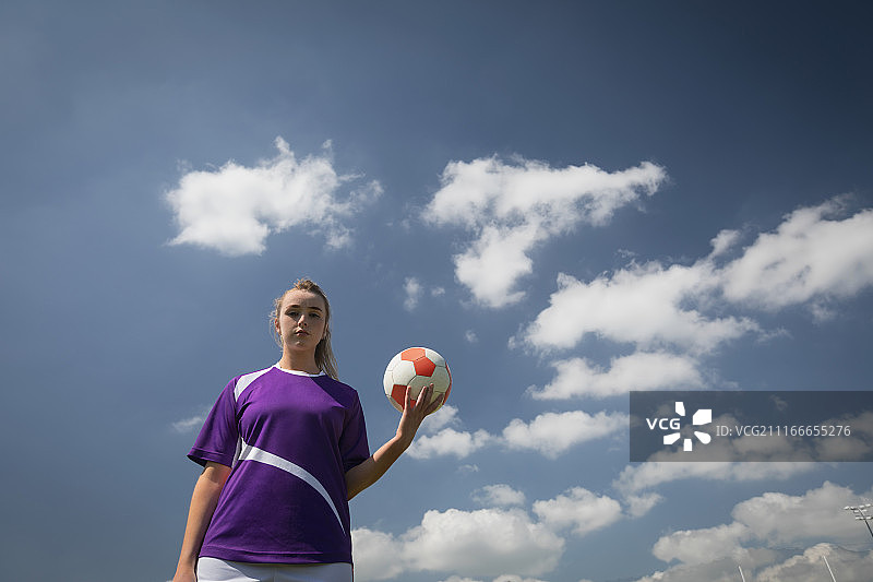 仰视角度拍摄的 holding 足球的女人图片素材