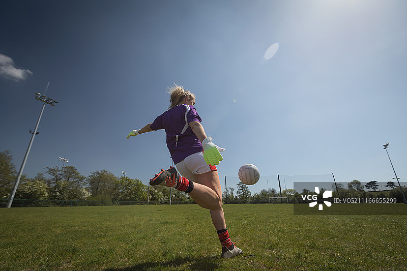 女运动员踢足球的后视图图片素材