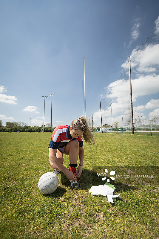 守门员在球场上系鞋带的全身照图片素材