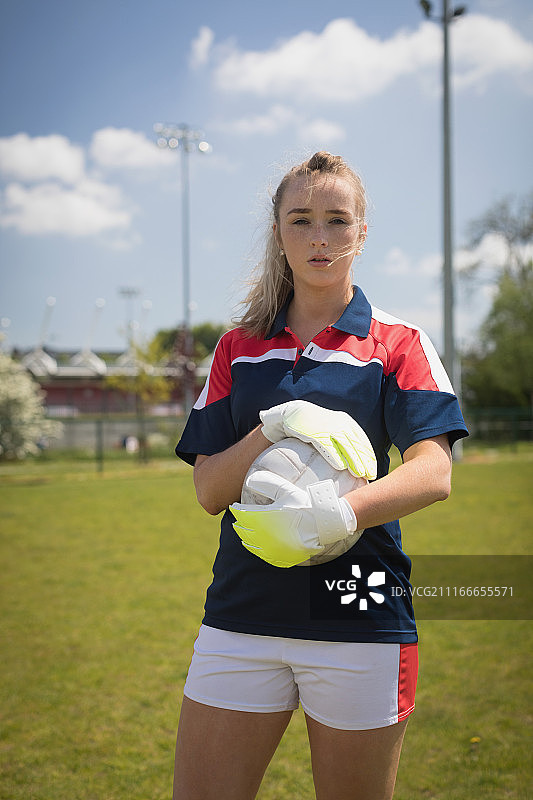 拿着球的女守门员在球场上的肖像图片素材