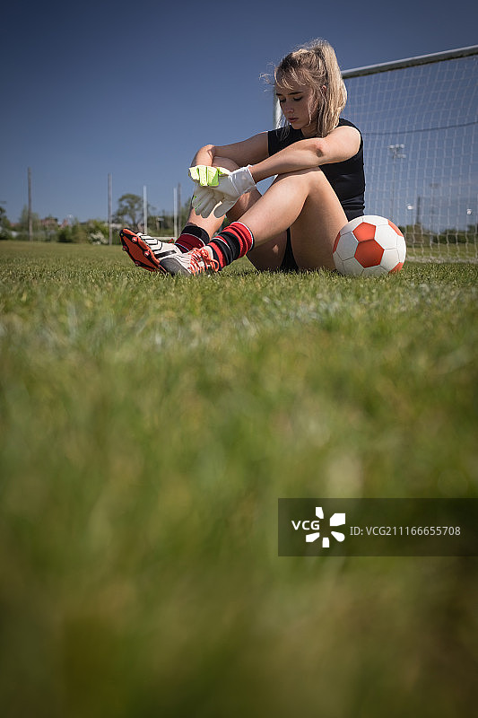 坐在球场上的足球运动员全身照图片素材