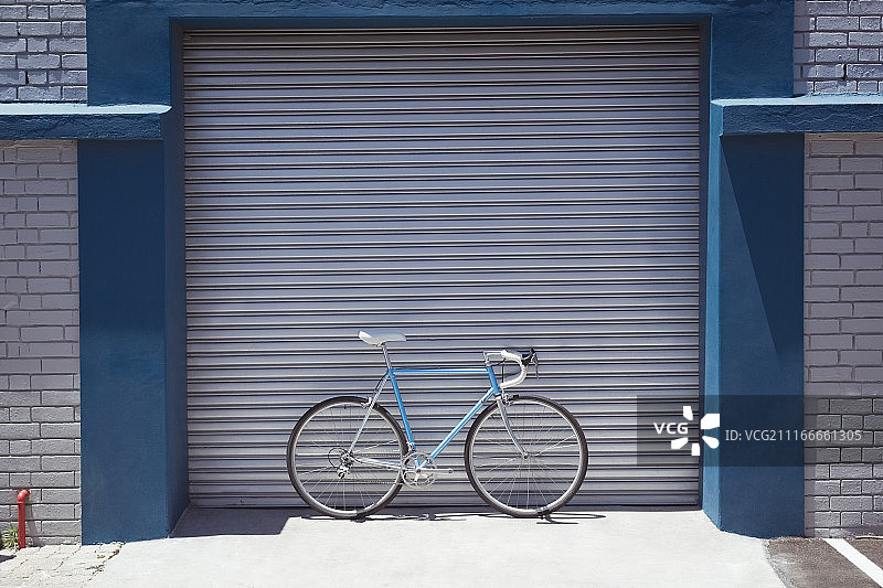 停在关闭的工坊旁的复古自行车图片素材