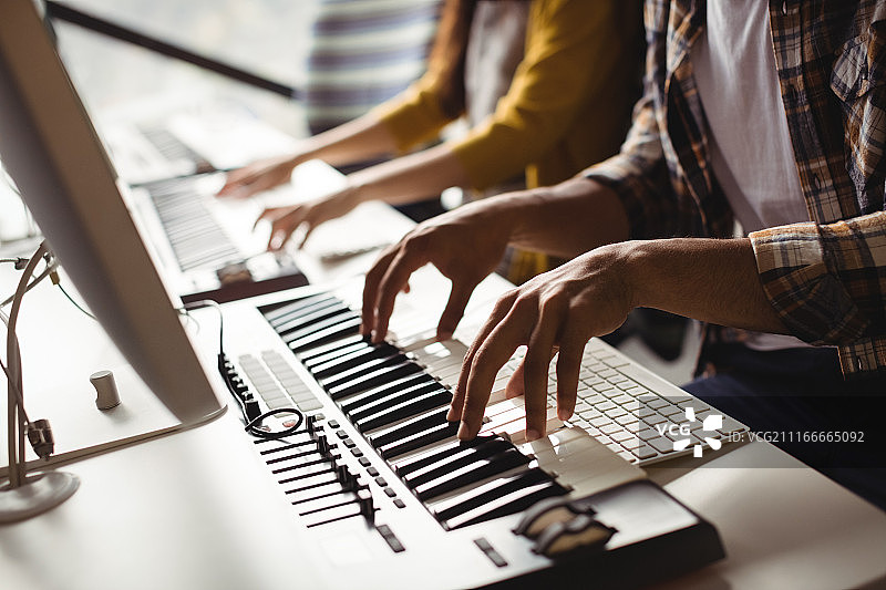 演奏电子琴的录音师的腰部特写图片素材